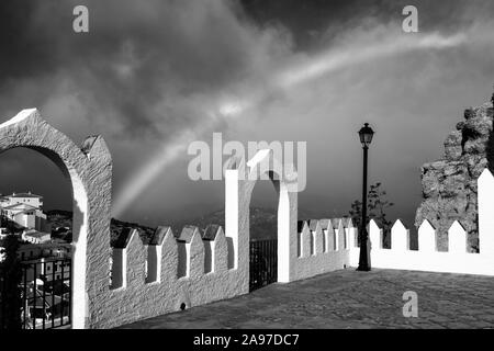 Le immagini in bianco e nero di un arcobaleno sopra la cima della montagna pueblo di Comares, Axarquia, Malaga, Andalusia, Costa del Sol, Spagna, Europa Foto Stock