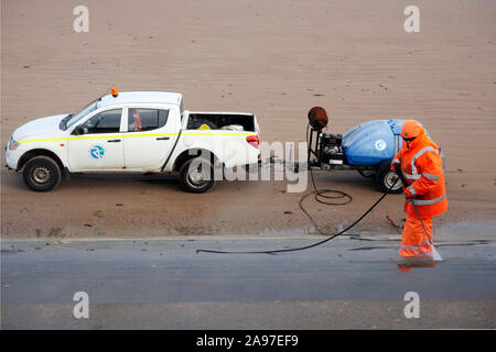 Redcar e Cleveland Consiglio lavoratore usando alta pressione di eiezione di acqua per pulire le fasi di fornire un accesso sicuro a Redcar beach Foto Stock