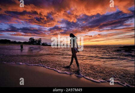 Una giovane donna cammina lungo la spiaggia Makalawena sulla Big Island delle Hawaii Foto Stock