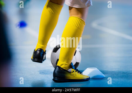 Il Futsal allenamento per il calcio. Unico giovane giocatore di futsal con sfera sulla formazione. Close up di gambe di futsal calciatore. Piscina calcio europeo pratica uni Foto Stock