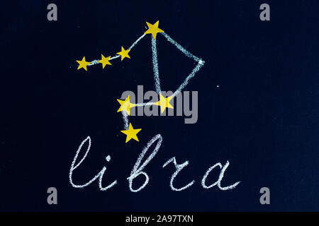 Constellation Libra disegnato in gesso e stelle dorate su una lavagna cercando come una notte di cielo stellato Foto Stock