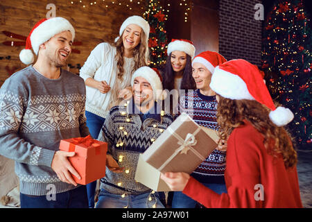 Happy amici con doni per celebrare il Natale Foto Stock