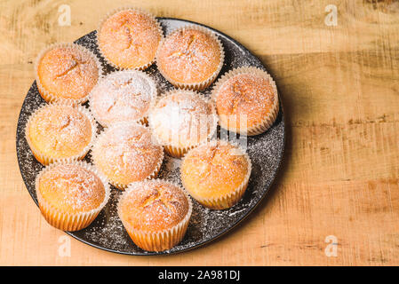 In casa apple muffin con zucchero bianco in polvere sul tavolo di legno Foto Stock