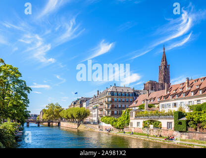 Il campanile della cattedrale di Notre Dame a Strasburgo, Francia, è sporgente al di sopra dei palazzi del centro storico bagnata con il fiume Ill. Foto Stock