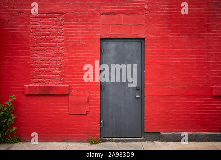 Sportello in acciaio in un vecchio rosso un muro di mattoni. Foto Stock