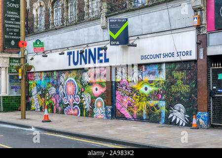 La collaborazione di graffiti da Nathan Bowen e Harry Blackmore su un vuoto e di lasciare che il tunnel di sconto negozio calzatura a Bromley High Street. Foto Stock