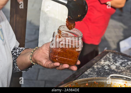 Appena cotti e freschi Ajvar in vasi sul tavolo. In attesa di degustazione. Foto Stock