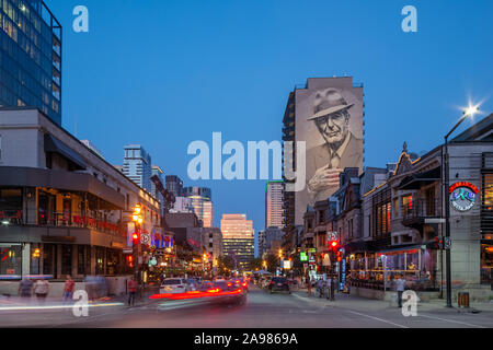 Illuminata Leonard Cohen murale sulla Crescent Street vista da De Maisonneuve boulevard da El Mac/Gene Pendon, del centro cittadino di Montreal, Quebec, Canada Foto Stock