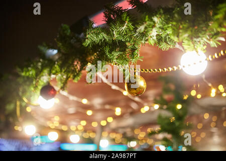 Albero di Natale decorato su strada con sfere, giocattoli, lampade e ghirlande Foto Stock