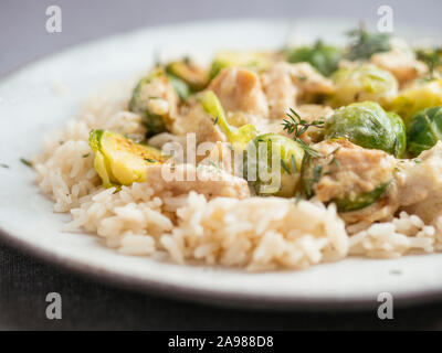 Arrosto di cavolini di Bruxelles con chickun vegana e una salsa Alfredo sul riso Foto Stock