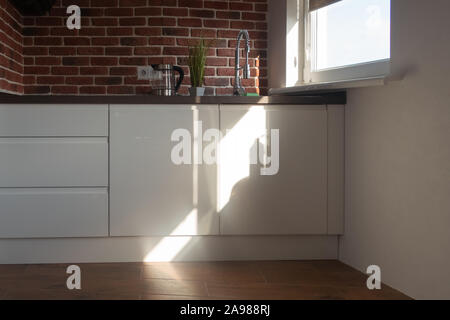 Cucina - sala da pranzo. Interno di un moderno appartamento. La luce solare diretta dalla finestra Foto Stock