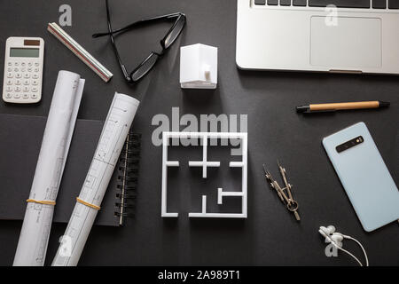 Ingegner architetto scrivania in ufficio. Blueprint piani e modello di casa, edificio residenziale progetto in bianco e nero, vista dall'alto Foto Stock