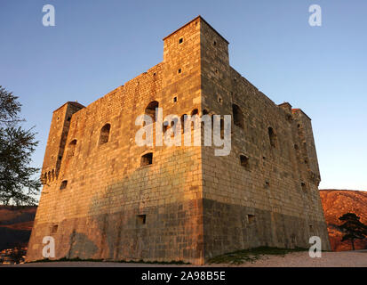 La vista del medievale castello di pietra torre della città croata di Senj, illuminato dal sole al tramonto Foto Stock