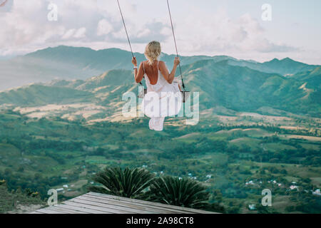 Bellissima vista della giovane donna swing sulla sommità del mountan Redonda nella Repubblica Dominicana. Nozione di viaggio, vacanza, turismo Foto Stock