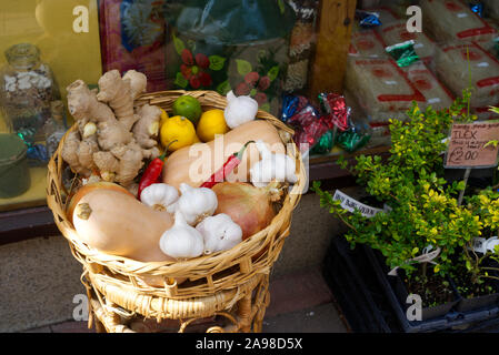 Cestello di organico lo zenzero, la zucca, peperoncini, limoni e limette per la vendita in un intero negozio di alimentari sulla basilica di Santa Maria della strada a Weymouth Dorset, Regno Unito Foto Stock