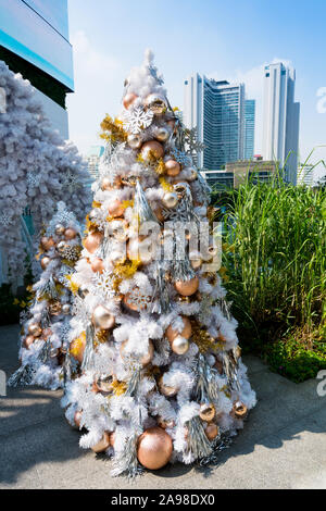 Christmas baubles appeso il bianco albero di Natale all'entrata dell'Emporium x EmQuartier il centro commerciale per lo shopping a Bangkok, in Thailandia. Foto Stock