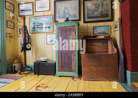 Barca a vela dipinti, Sailor's hat, antico armadio in legno e canottaggio remo in ingresso con ancore dipinta su giallo tavoloni all'interno della vecchia casa 1835 Foto Stock