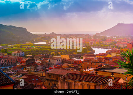 Vista dall'alto sulla città di Bosa con case con tetti rossi, montagne con alberi verdi e il fiume Temo che fluisce nel mar Mediterraneo. Ubicazione th Foto Stock