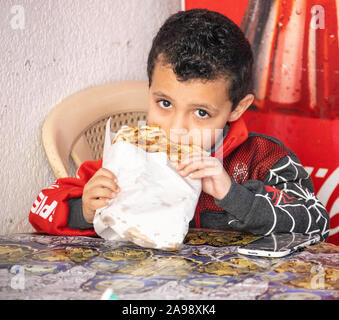 Ragazzo locale di mangiare in zona Souk, Sidone (Saida), Libano Foto Stock