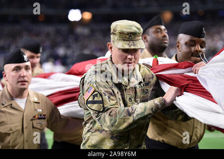 Arlington, Texas, Stati Uniti d'America. Decimo Nov, 2019. I membri degli Stati Uniti le Forze Armate portare la bandiera fuori campo dopo l'inno nazionale prima della prima metà del NFL di una partita di calcio tra il Minnesota Vikings e Dallas Cowboys di AT&T Stadium di Arlington, Texas. Shane Roper/Cal Sport Media/Alamy Live News Foto Stock