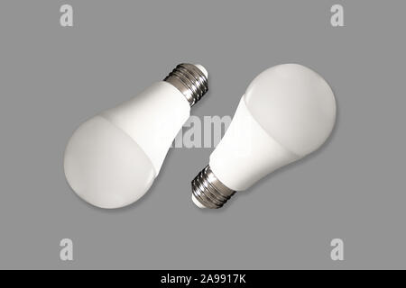 Due LED lampadina luci e lampadine a basso consumo energetico su tavola su sfondo grigio. Concetto di risparmio energetico Foto Stock