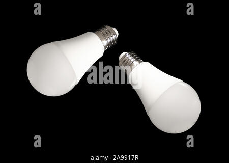 Due LED lampadina luci e lampadine a basso consumo energetico su tavola su sfondo nero. Concetto di risparmio energetico Foto Stock