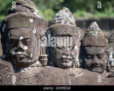 Primo piano delle gigantesche statue di dei e demoni di rivestimento del causeway a Angkor Thom in Cambogia. Foto Stock