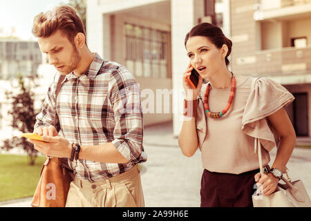 Emotivo femmina giovane persona che parla al telefono Foto Stock