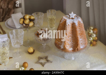 Italiano dolce di Natale di Pandoro sul tavolo con oro decorazioni natalizie e dolcezza, cioccolatini e star cookies.bella Xmas cibo ga Foto Stock