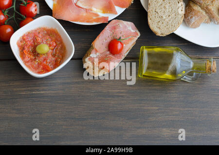 Vista dall'alto di spagnolo tapa con Prosciutto Iberico( prosciutto iberico), tumaca ciotola (pomodoro strofinato ), virgen olio d'oliva Bottiglia e crosta di pane rustico. La maggior parte Foto Stock