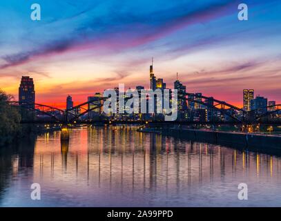 Skyline di Francoforte davanti al tramonto con grattacieli illuminati e riflessi nelle principali, Frankfurt am Main, Hesse, Germania Foto Stock