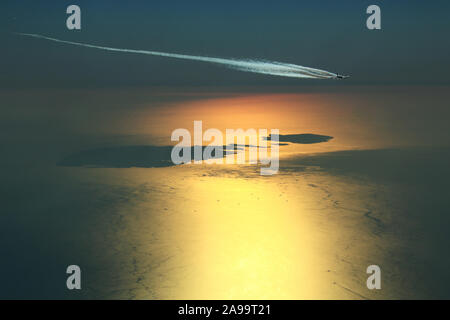 I gas di scarico del motore contrails formando dietro un Airbus A380 Super Jumbo mentre sorvolo l arcipelago maltese durante un bel tramonto Foto Stock