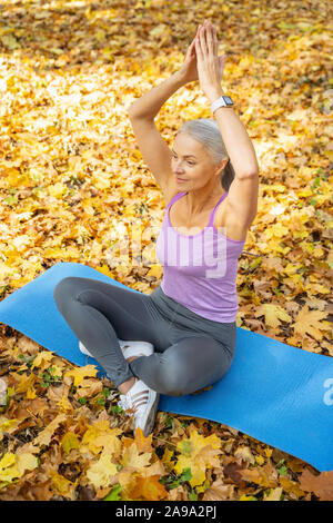 Signora Serena seduto yoga posa Foto Stock