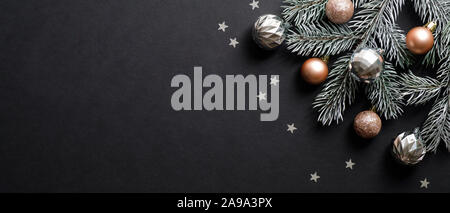 Banner di natale. Albero di Natale decorato di diramazione di rame e di argento sfere a colori su sfondo nero con coriandoli. Ampia Xmas banner mockup, testata, fl Foto Stock