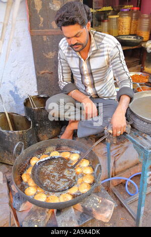 BUNDI, Rajasthan, India - 10 dicembre 2017: Ritratto di un venditore ambulante di cottura e la vendita di prodotti alimentari all'interno della città vecchia Foto Stock