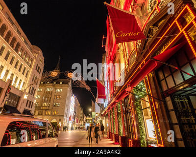 Decorazioni natalizie su New Bond Street a Londra con la facciata rossa di Cartier. Foto Stock