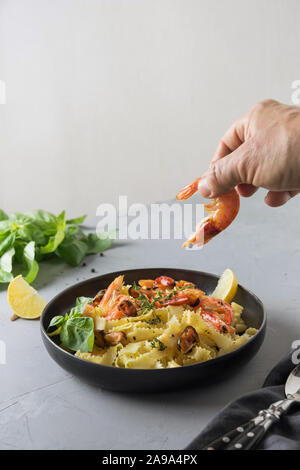 Reginelle Pasta con pesce, gamberi, cozze in piastra nero su grigio tavolo di pietra, vicino. Piatto tradizionale nel ristorante italiano. Foto Stock