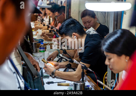 I concessionari esaminando pietre di giada al Mercato della Giada, Mandalay Myanmar. Foto Stock