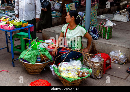 Una donna locale vendono spuntini presso il Mercato della Giada, Mandalay Myanmar Foto Stock