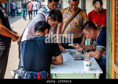 Un concessionario esaminando Jade al Mercato della Giada, Mandalay Myanmar. Foto Stock