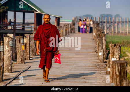 Un monaco buddista attraversa U Bein Bridge, Amarapura, Mandalay Myanmar. Foto Stock