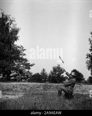 Un soldato della Wehrmacht che throing una bomba a mano a un esercizio, Germania 1930s. Foto Stock