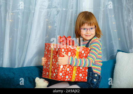 Ragazza Masha tenendo una scatola con un regalo e sorridente Foto Stock