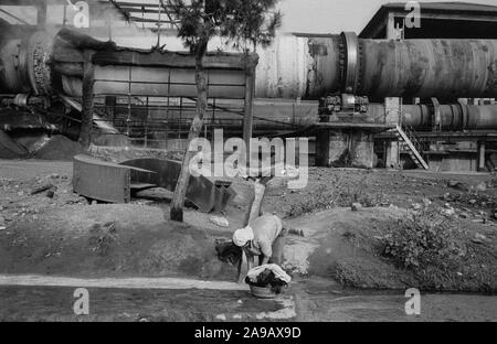 Facendo Servizio lavanderia in un acqua uscita dalla fabbrica del cemento, a filo KRUJE, ALBANIA, 1992 Foto Stock