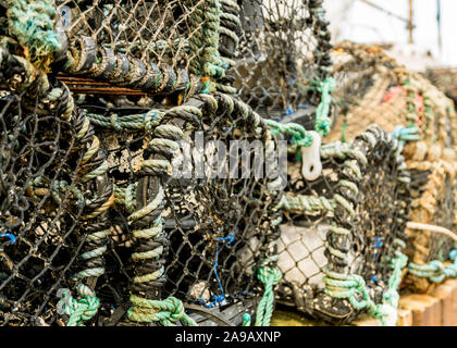 Lobster Pot impilate con la parete del porto Foto Stock