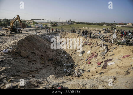 14 novembre 2019, Territori palestinesi e Deir al Balah: palestinesi ispezionare un cratere realizzato da un missile israeliano che ha distrutto una casa e ucciso otto membri dell'Abu Malhous famiglia a Deir al-Balah. Foto: Mohammed Talatene/dpa Foto Stock