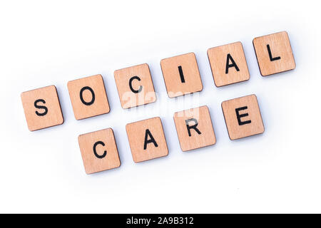 Assistenza sociale, farro con lettera in legno piastrelle. Foto Stock
