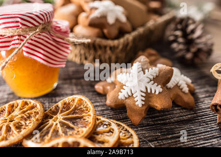 Pan di zenzero biscotti di Natale con un vasetto di miele sul tavolo da cucina - Close-up. Foto Stock