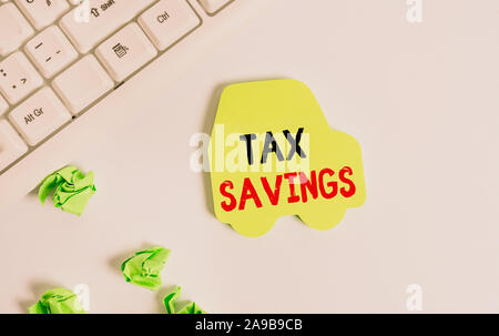 La grafia la scrittura di testo risparmio fiscale. Foto concettuale solo una porzione del reddito è imponibile pagare un importo ridotto dell'imposta nota verde carta in forma o Foto Stock