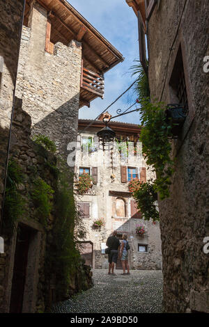 Via Fratelli Bandiera, uno stretto vicolo che conduce alla piazza centrale nel medievale borgo montano di Canale di Tenno, Trentino-Alto Adige, Italia Foto Stock